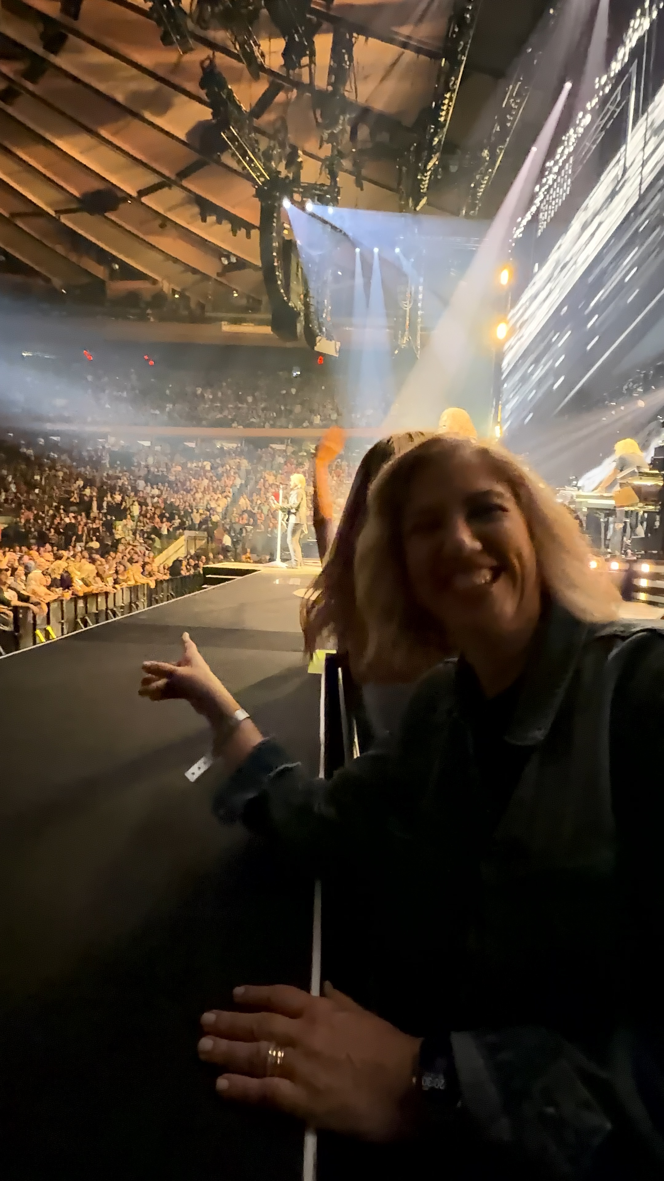 Show do Bon Jovi, capturado por uma câmera de celular na plateia, com o palco ao fundo e a energia da arena em torno.